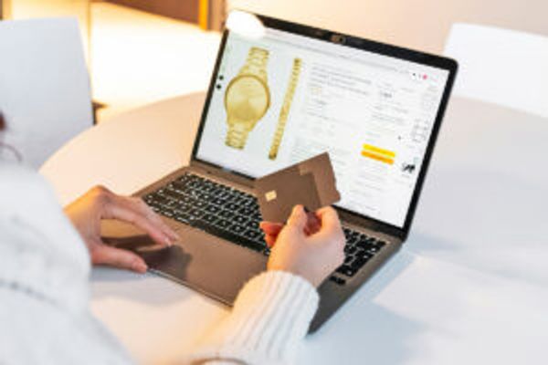Person holding credit card in front of laptop