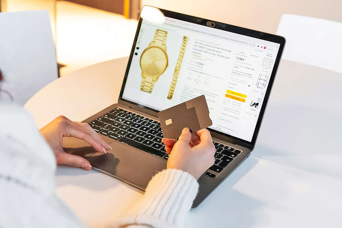 Person holding credit card in front of laptop