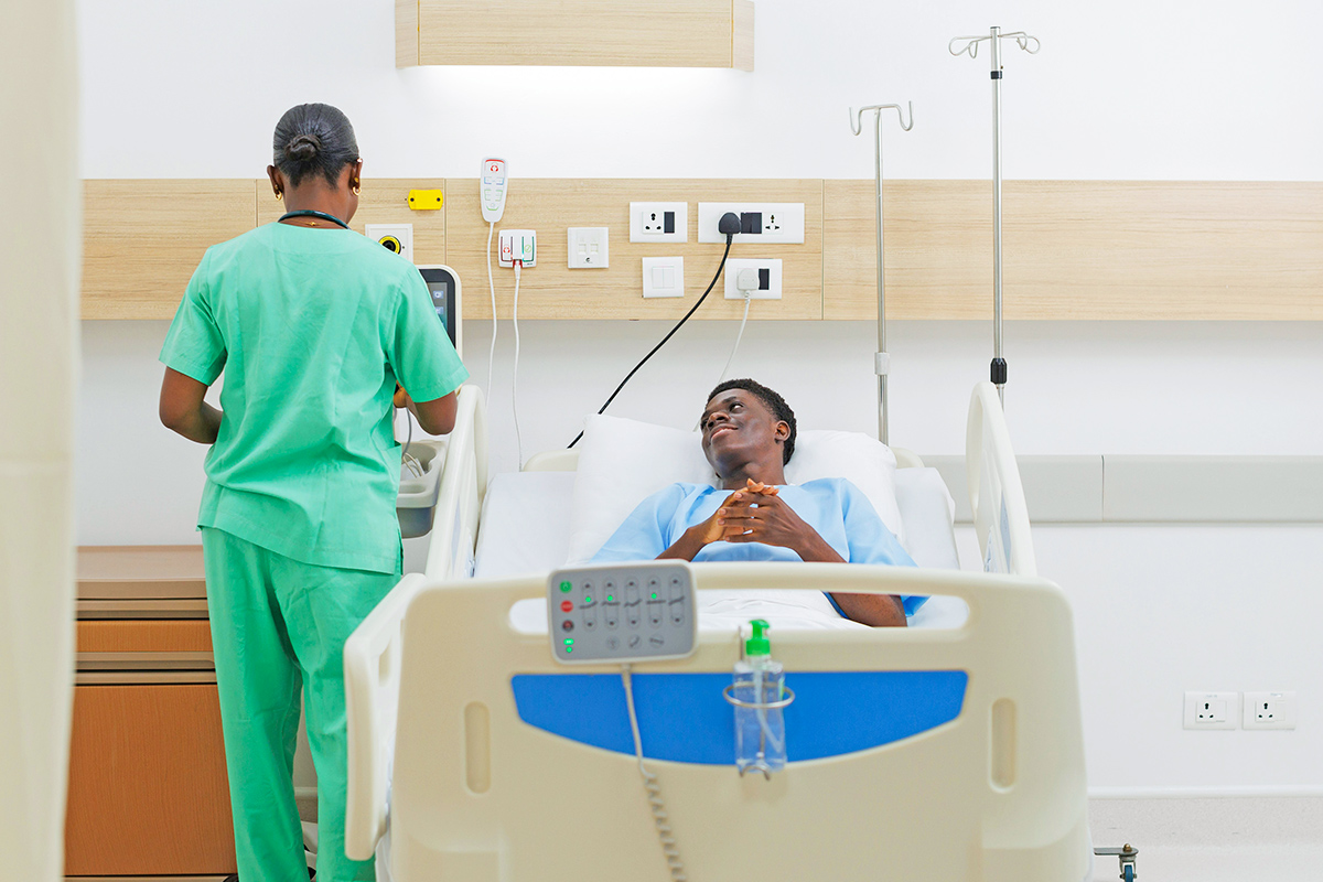 Nurse and man in hospital bed