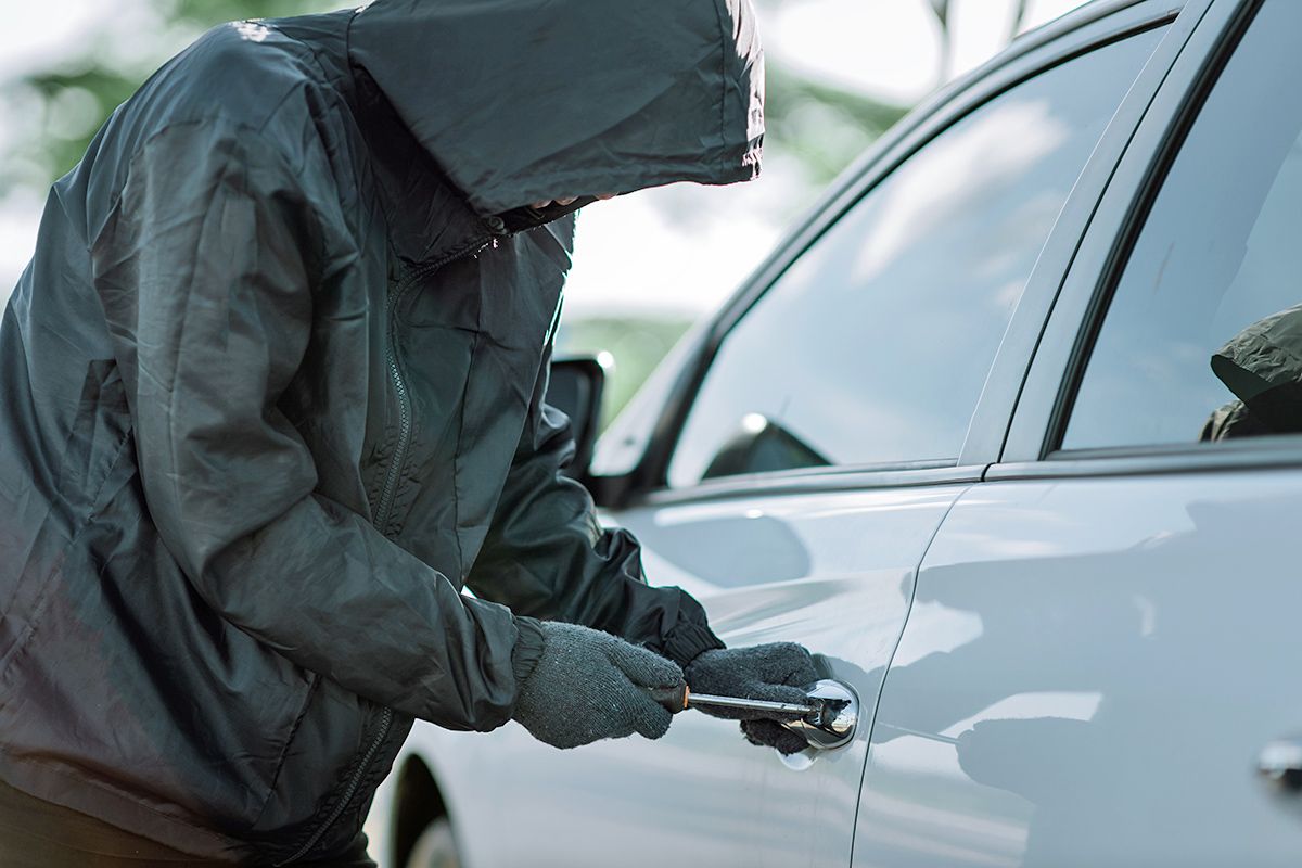 Person trying to break into car