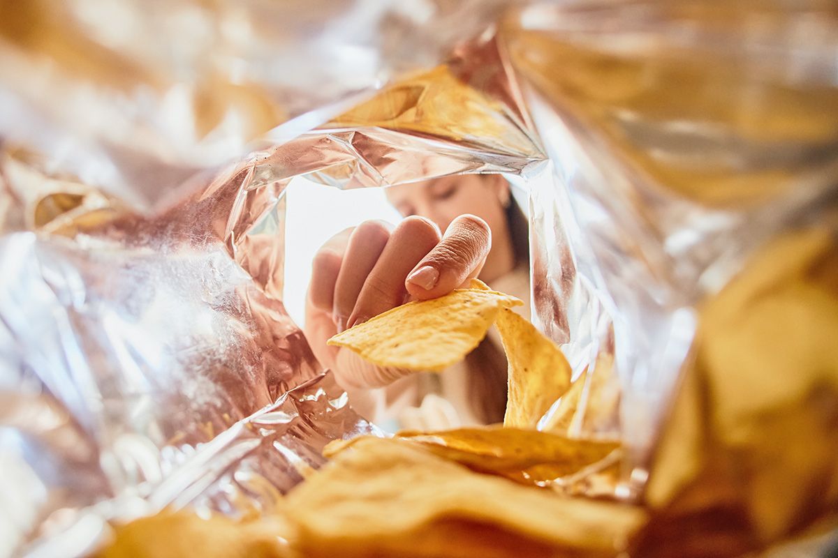 Woman taking chip out of bag