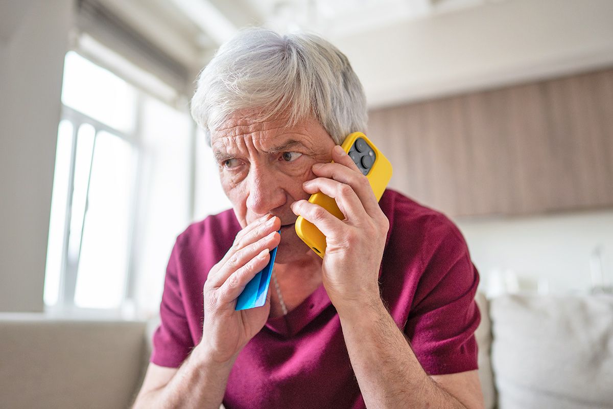 Concerned man on phone holding credit card