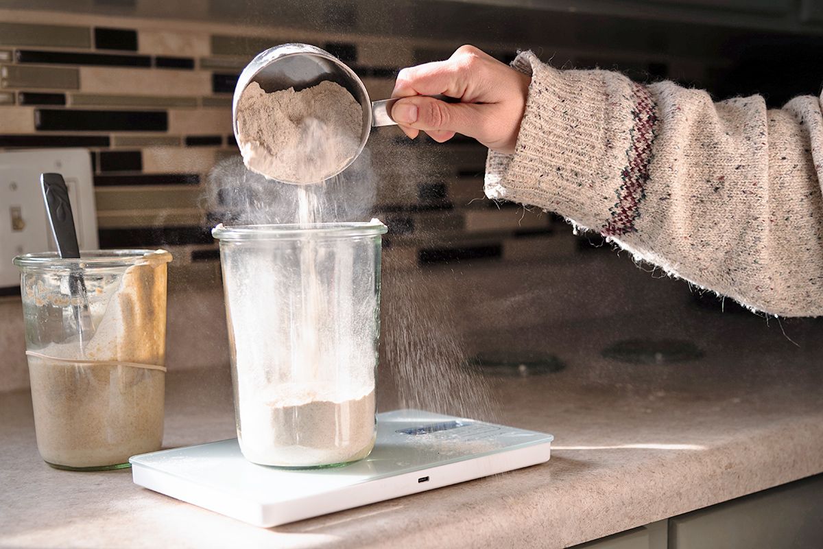 Pouring flour into a canister on a scale