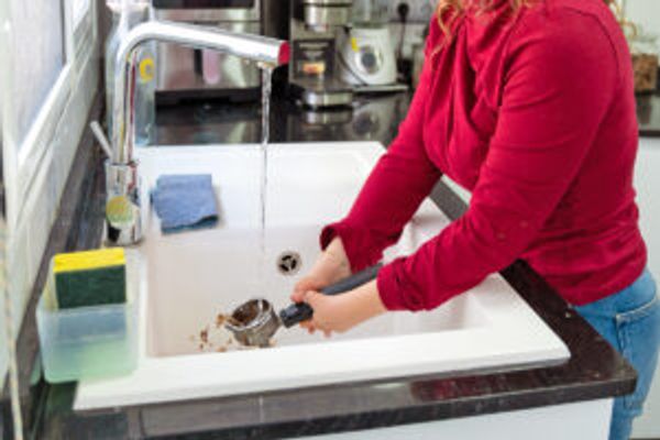 Person washing part of a coffee machine