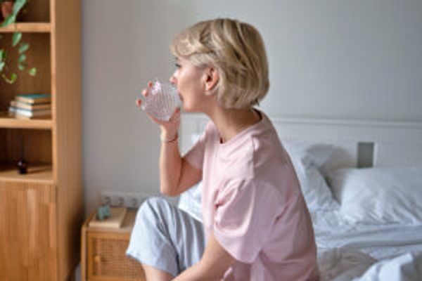 Woman in bed drinking water